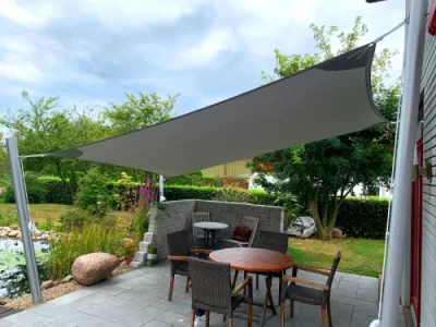 Modernes Sonnensegel über Terrasse im grünen Garten