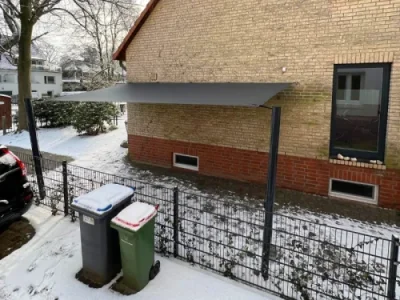 Modernes Sonnensegel über Terrasse im grünen Garten