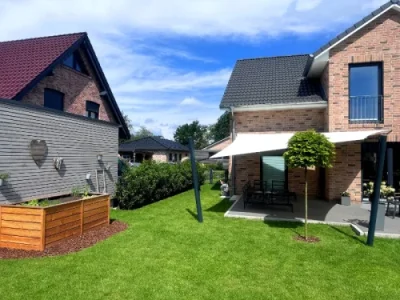 Modernes Sonnensegel über Terrasse im grünen Garten
