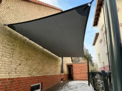 Modernes Sonnensegel über Terrasse im grünen Garten